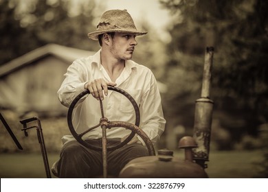 Young Farmer Driving A Red Old Vintage Tractor