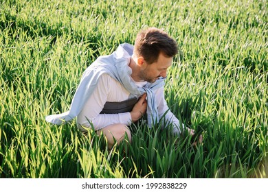 Young Farmer With Folder Under His Arm Sitting In Field 40 Years Old Checking His Forage Crop, Small Bussiness Concept Photo