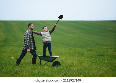 The Young Farmer And His Son Have Fun In The Field