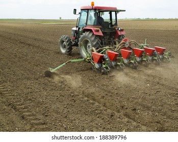 Young Farmer Sowing Crops At Field With Pneumatic Sowing Machine