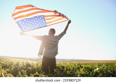 A young farmer stands with a USA flag in a soybean field. The concept of the US agricultural industry - Powered by Shutterstock