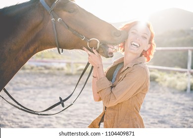 Young Farmer Woman Playing With Her Horse In A Sunny Day Inside Corral Ranch - Concept About Love Between People And Animals - Focus On Girl Face