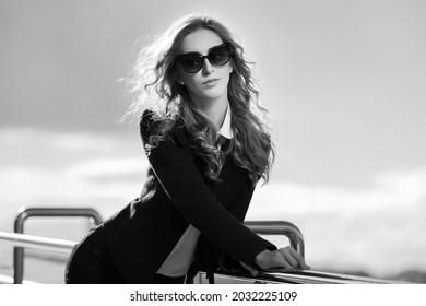 Young Fashion Blonde Business Woman Leaning On Railing Stylish Female Model In Black Jacket And Sunglasses 