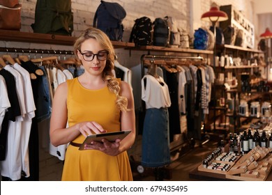 Young Fashion Boutique Owner Checking Information In Her Tablet Computer