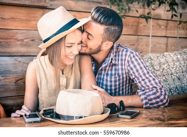 Young fashion couple of lovers at beginning of love story - Handsome man whispers kisses in pretty woman ear - Relationship concept with boyfriend and girlfriend together - Warm retro filter