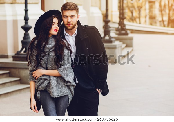 晴れた秋に古い通りでポーズをとる若いファッションカップル 美しい女性とハンサムなおしゃれな彼氏が街で抱きしめている クリーム状の秋の日差し の写真素材 今すぐ編集