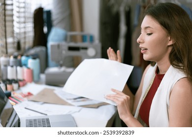 Young fashion designer live steraming with camera presenting new sketch of clothing design to audience. SME small business owner online marketing and selling. - Powered by Shutterstock