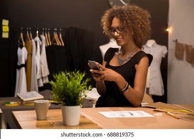 A young fashion designer on her atelier making a phone call - Powered by Shutterstock