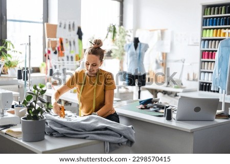 Young fashion designer working at her workplace
