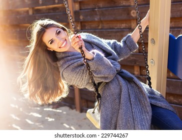 Young fashion girl having fun on swing - Powered by Shutterstock