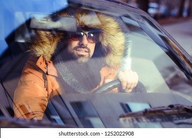 Young Fashion Handsome Bearded  Man Driving A  Car In A Sunny Winter Day 