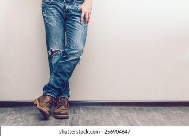 Young fashion man's legs in jeans and boots on wooden floor - Powered by Shutterstock