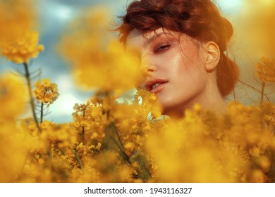  Young fashion model portrait with ginger hair and blue eyes in yellow rapeseed field