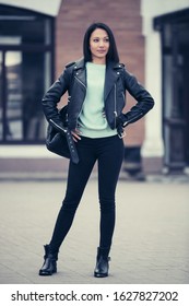 Young Fashion Woman With Backpack On City Street Stylish Female Model In Black Leather Jacket And Skinny Jeans