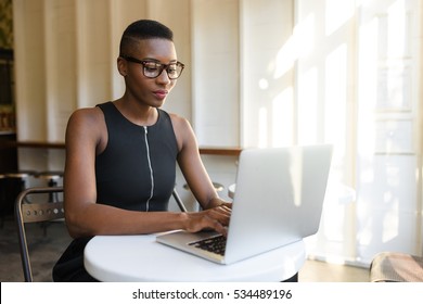 Young Fashionable African Business Woman Working Hard At The Cafe On The Laptop