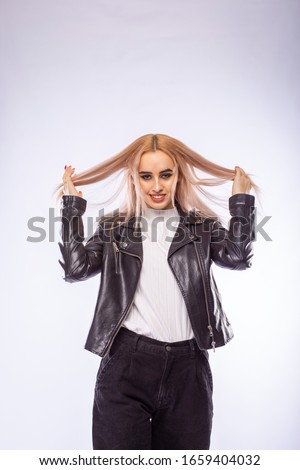 Young fashionable blonde woman in black leather jacket