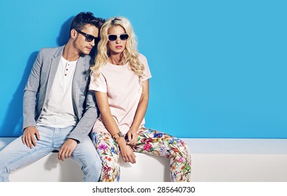 Young fashionable couple on blue background