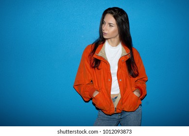 Young fashionable teenager woman near the blue wall