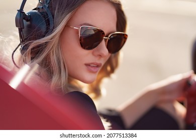 Young Fashionable Woman Pilot In Headset Ready To Fly In Small Red Airplane. Beautiful Life, Aristocratic Lady In Black Dress In Blonde Wavy Hair.