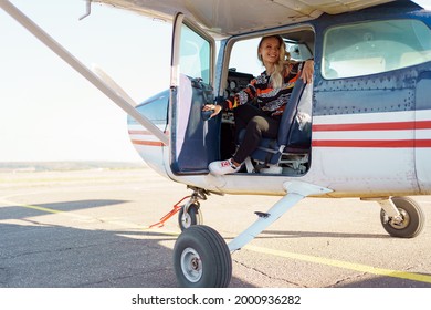 Young Fashionable Woman Pilot Ready To Fly, Start Training, In Small Airplane. Learning Process.