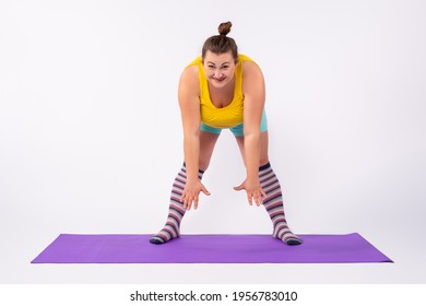 Young Fat Caucasian Woman Bending Over A Sports Rug. A Chubby Girl Stretching From A Distance On A Yoga Mat. High Quality Photo