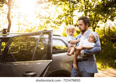 Young Father With Baby And Toddler By The Car.