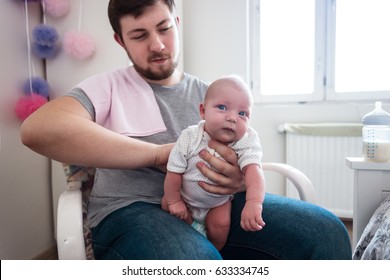 Young Father Burping His Newborn Daughter, Holding Her Affectionately.