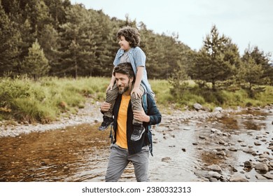 Young father carrying his son on his back in nature - Powered by Shutterstock