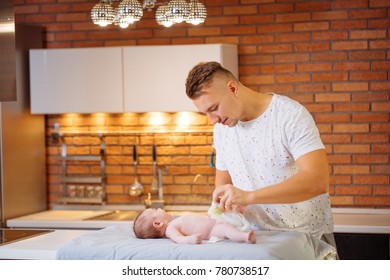 Young Father Is Changing Nappy To His Baby Boy