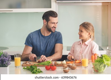 Young Father And Daughter Cooking Meal Together 