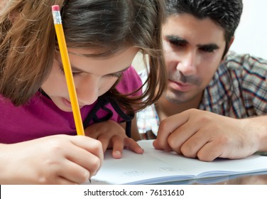 Young father helping her daughter with her school project at home - Powered by Shutterstock