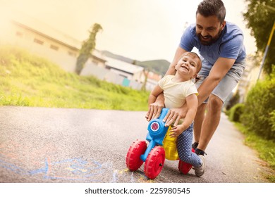 Young father with her little daughter on motorbike in green sunny park - Powered by Shutterstock