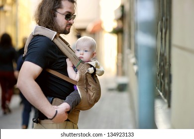 Young Father And His Baby Girl In A Baby Carrier