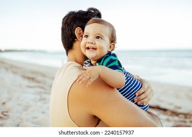 A young father and his baby son spending quality time at the beach - Powered by Shutterstock