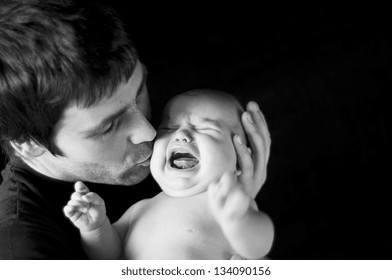 Young Father With His Crying Baby In Studio