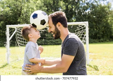 Young father with his little son playing football on football pitch - Powered by Shutterstock