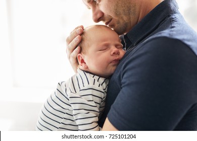 Young Father Holding Her Newborn Baby