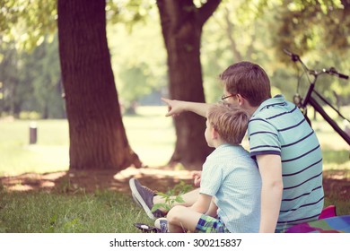 Young father with little sun dreaming at summer park - Powered by Shutterstock