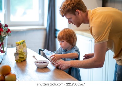 Young Father Making Breakfast For His Little Son