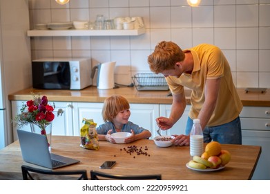 Young Father Making Breakfast For His Little Son