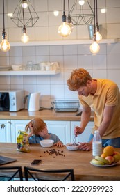 Young Father Making Breakfast For His Little Son