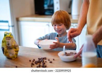 Young Father Making Breakfast For His Little Son