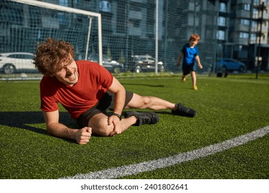 Young father soccer player injured his leg during match with son - Powered by Shutterstock