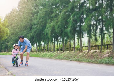 Young Father Spend Time With Cute Little Asian 2 Years Old Toddler Boy Child, Dad And Son Having Fun With Balance Bike (run Bike) On Nature, Dad Tech Son To Ride Bike, Father's Day Concept - Film Look