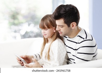 Young Father Studying His Little Daughter How To Use Internet Safety At Home. 