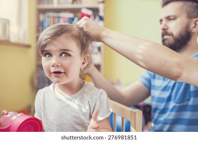 Young father styling hair of his daughter - Powered by Shutterstock