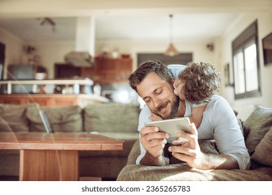 Young father taking a selfie on a smartphone with his son on the couch in the living room at home - Shutterstock ID 2365265783