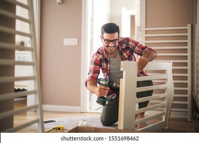 Young father using electric screwdriver to assemble the crib for new family member - Powered by Shutterstock