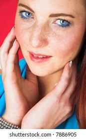 Young Female Adult Fashion Model With Natural Red Hair And Freckles In A Blue Summers Dress With White Belt (red Textured Faux Leather Background)