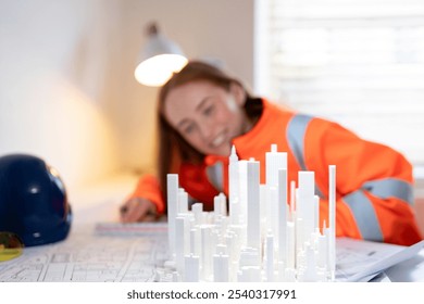 Young female architect meticulously designs a modern cityscape model in her bright office during the day - Powered by Shutterstock